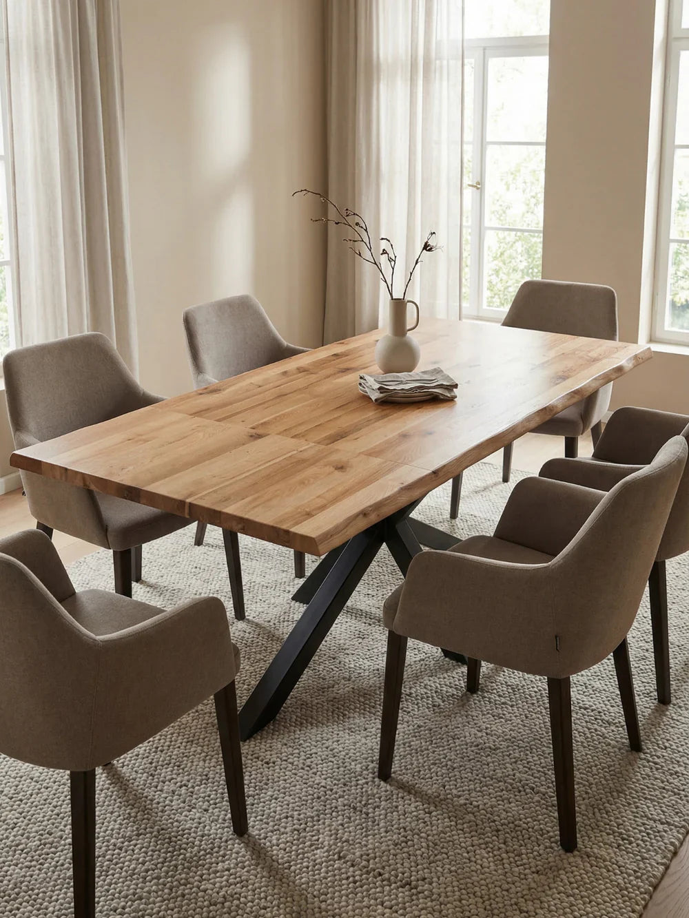 Ausziehbarer Massivholztisch aus Eiche mit Baumkante und grauen Armlehnstühlen im hellen Esszimmer